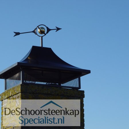 Een schoorsteenkap zadeldak met een windwijzer wereldbol
